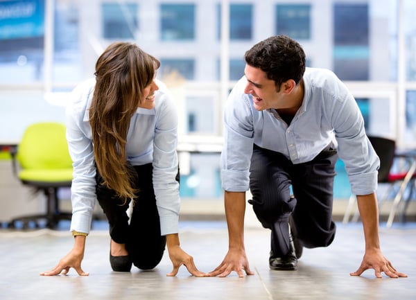 Competitive business couple ready for a race at the office